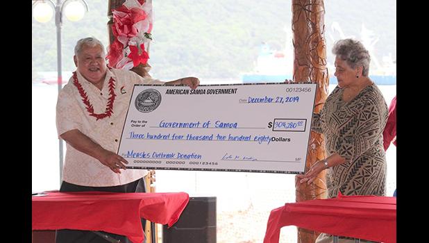First Lady Cynthia Malala Moliga (right) presents check to PM Tuilaepa 