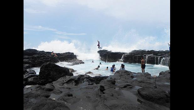 Kids jumping into an ocean tide pool
