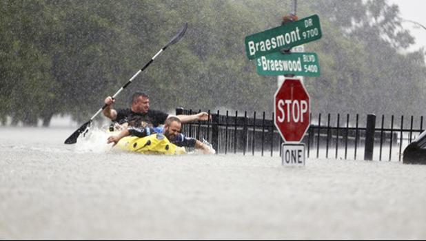 Flooding in Houston with two men paddling in the water