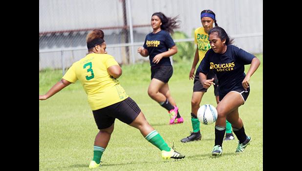 A Cougars player (right) dribbling away from a Leone defender during