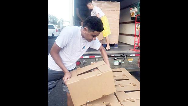 Ā’oga Samoa boys unloading cartons of food