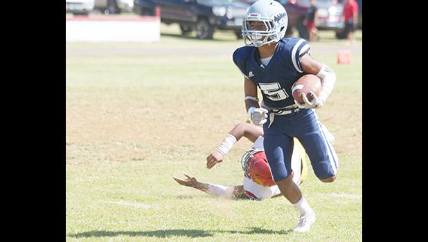 Samoana Sharks Sophomore at running back, Marcus Samia beating a Tafuna defender