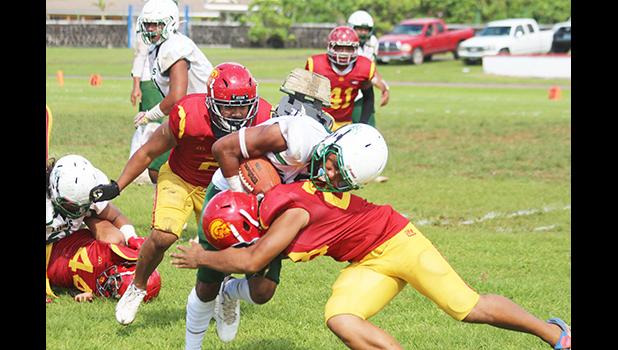Joshua Taani of the Leone Lions is met by a Tafuna Warrior defender