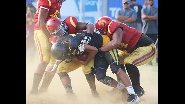 Nu’uuli Wildcats quarterback Nathaniel Maea is swallowed in the backfield for a loss by