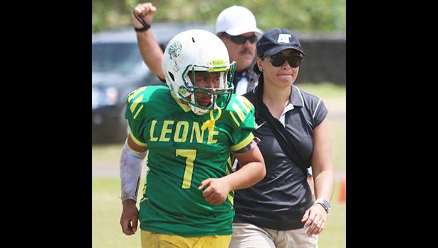 ASHSAA ATC Florence Wasko helping injured Leone Lions quarterback Isaiah Elisara off