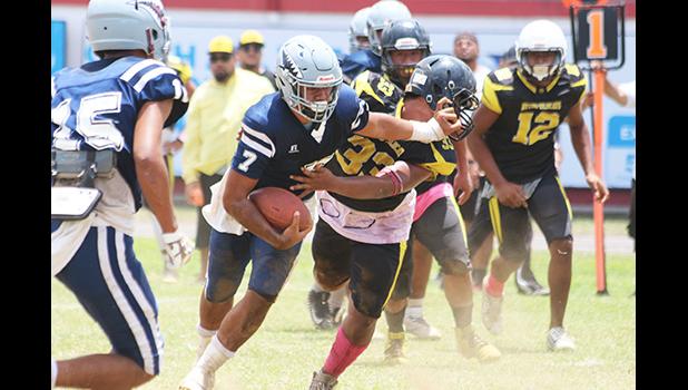 Samoana Sharks quarterback Viliamu Tanielu stiff arms a Nu’uuli Wildcat defender 
