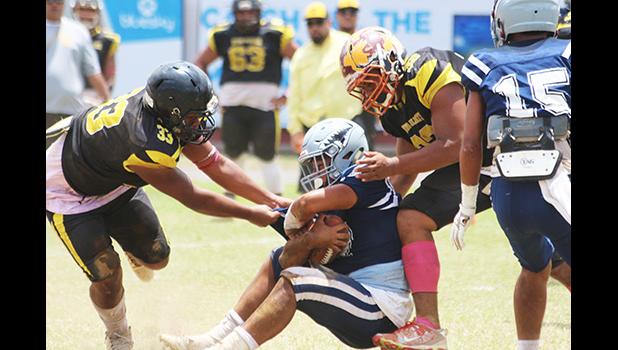 Charlie Toa Leama of Nu’uuli and a teammate sack Samoana’s quarterback Viliamu Tanielu