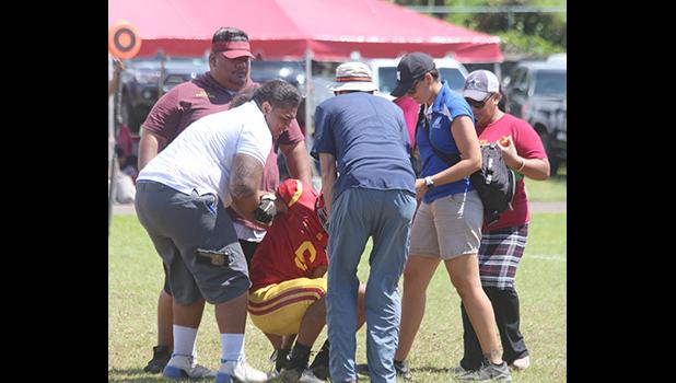 ASHSAA ATC Florence Wasko and Dr. Edwards helping Tafuna Warriors wide receiver Isaiah Gurr