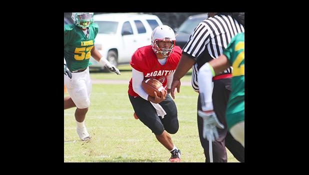 Vikings quarterback Raemos Fano, scrambling with the ball – just before taking a vicious hit from Aden Mao of the Lions that took Fano out of the game, and maybe the season, in the first half of their varsity match up.  [photo: TG]