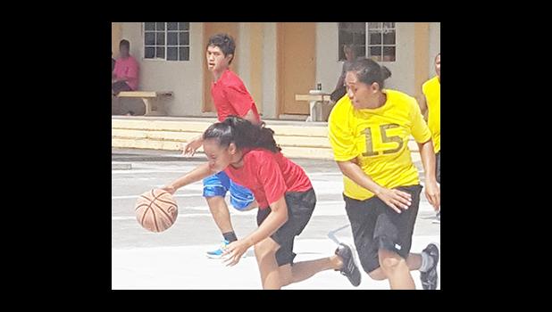 Dorvida Fuiava dribbling away as Leata Seumanu tries to stop her during a match-up between the yellow team and red team at last Saturday's basketball showdown in Malaeimi. [Courtesy photo]