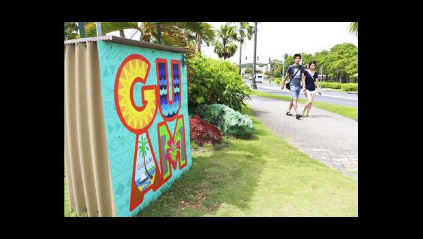 In this May 15, 2017, file photo, tourists walk through a shopping district in Tamuning, Guam. Security and defense officials on Guam said on Aug. 9, 2017, that there is no imminent threat to people there or in the Northern Mariana Islands after North Korea said it was examining its operational plans for attack. (AP Photo/Haven Daley, File)