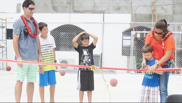Krista Corry cuts the ribbon to officially open Pacific Horizon School's new half court. Also pictured are Jason Corry and three of their sons, Brady, Skyler and Riley.  [Courtesy photo]