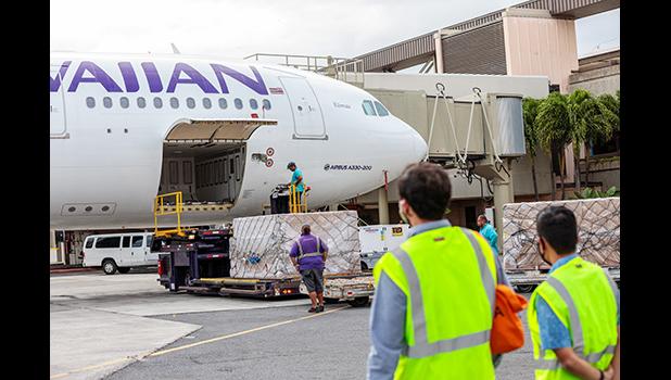 Hawaiian Air employees unload HAL plane bringing masks to Hawaii.