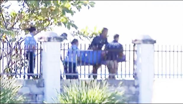   CAUSE OF DEATH UNDER INVESTIGATION: Body of the woman found at sea on Monday morning being carried by Police officers. [Samoa Observer]