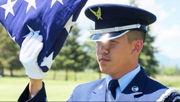 Senior Airman Darias Faaita preparing to present an American Flag to its recipient.
