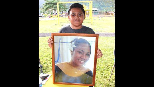 Eleven-year-old Malakai, posing for Samoa News with a portrait of his mother, Sabrina Seva’aetasi