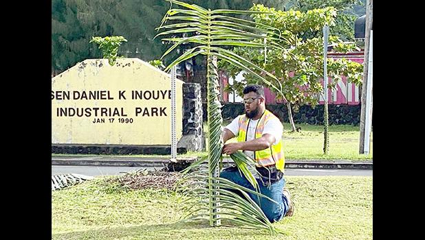 The  Sen. Daniel K. Inouye Industrial Park sign with man 