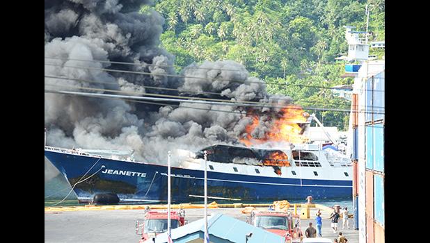 The Jeanette on fire and being towed out of the harbor