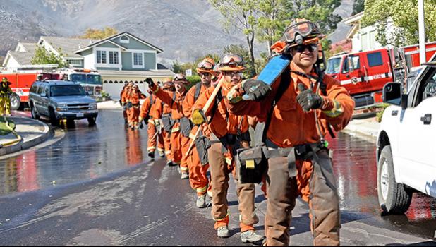 Firefighters march into an L.A. neighborhood threatened by wildfire.