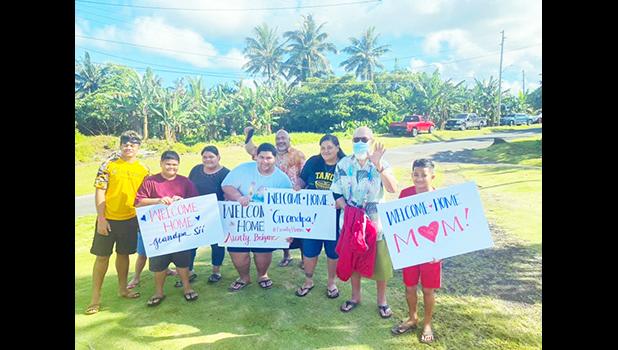 Families with signs welcoming their loved ones home