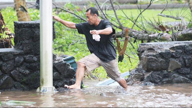 A man in Fagaalu navigating a flooded sidewalk area last week Friday — a typical sight during the aftermath of Tropical Storm Gita that hit the territory last Friday, followed up by a monsoon trough that dumped buckets of rain with high winds throughout the weekend.  [photo: TG]