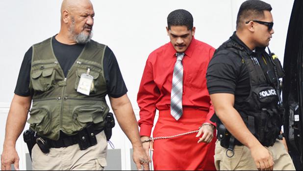 Manu Lefatia restrained and escorted by two police officers
