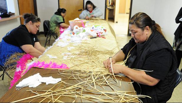 Felolins Mawong, left, and Tauva Filivaa, front, work with Sopa Saina, back left, and Falesoa Iaulalo on a mat for a family who lost a loved one. [Calixtro Romias / The Record]