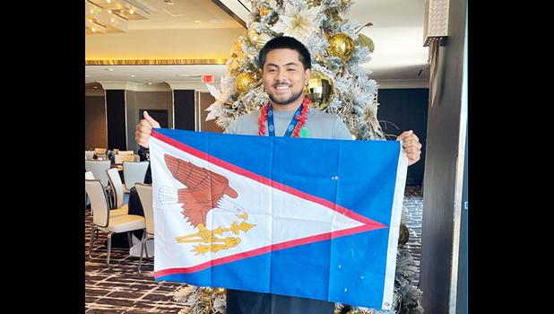 Mataio Suluai carrying the American Samoan flag