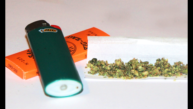 Marijuana buds, rolling papers and lighter