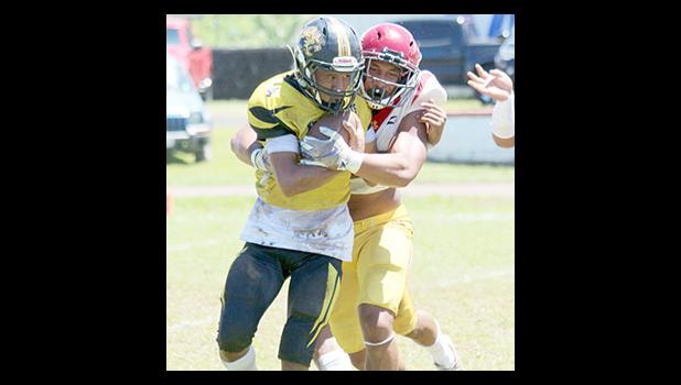 Tafuna Warriors Francisco Mauigoa and a Nuuuli Wildcat ball carrier