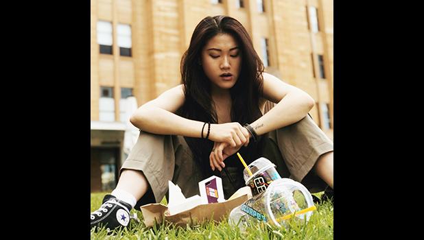 Young woman with empty junk food packages