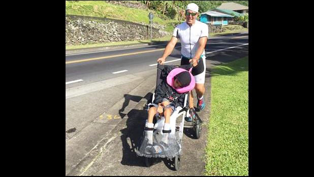 Matt Bracken, who took home second place during Saturday's Triathlon Olympic Division, is seen pushing Miracle, one of the Special Olympians on a stroller during the running portion of the competition.  [photo: Mark Espiritu]