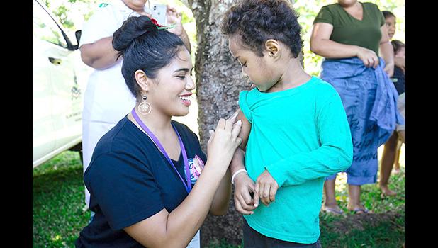 Fonoifafo Seumanu administering am MMR shot to a child