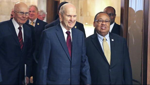 In this May 17, 2018 file photo, Mormon church President Russell M. Nelson, center, and Leon W. Russell, chairman of the NAACP board of directors, right, walk into a news conference, in Salt Lake City. The Mormon church on Friday, June 1, 2018, will celebrate the 40th anniversary of reversing its ban on black people serving in the lay priesthood, going on missions or getting married in temples, rekindling debate about one of the faith’s most sensitive topics. (AP Photo/Rick Bowmer, File)