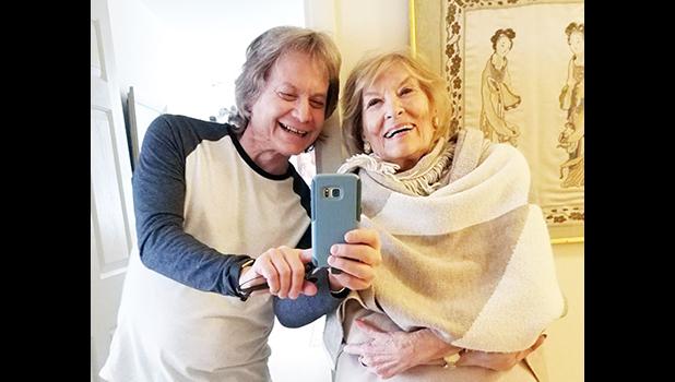 Leland Stein, left, takes a photo with his mother Sondra Green
