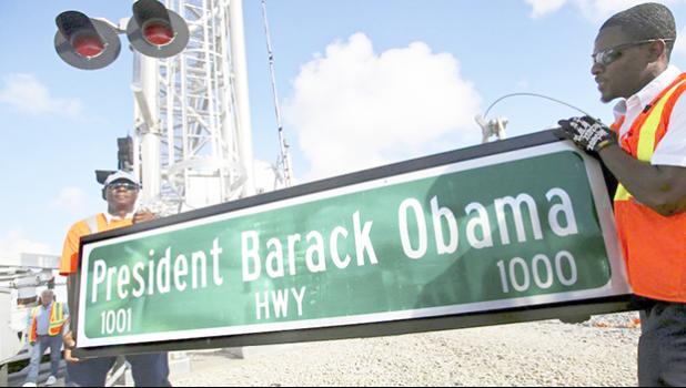 In this Thursday, Dec. 17, 2015 file photo, Dale Moncur, left, and Cedric Anderson of Palm Beach County Traffic Operations, hold a sign for the new President Barack Obama Highway in preparation to change it from the “Old Dixie Highway” in Riviera Beach, Fla. On Friday, Jan. 5, 2018, The Associated Press reported that stories circulating on the internet about President Donald Trump ordering the name of the highway changed back to “Old Dixie” are untrue. (Lannis Waters/Palm Beach Post via AP) In this Thursday, Dec. 17, 2015 file photo, Dale Moncur, left, and Cedric Anderson of Palm Beach County Traffic Operations, hold a sign for the new President Barack Obama Highway in preparation to change it from the “Old Dixie Highway” in Riviera Beach, Fla. On Friday, Jan. 5, 2018, The Associated Press reported that stories circulating on the internet about President Donald Trump ordering the name of the highway changed back to “Old Dixie” are untrue. (Lannis Waters/Palm Beach Post via AP)