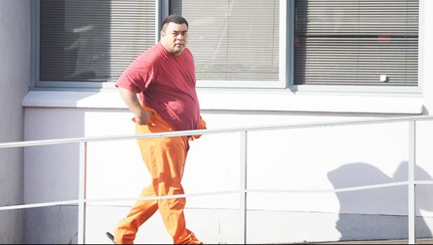 One of the four DPS officers, assigned to the Juvenile Detention Center, heading into the District Court last Friday morning for his initial appearance after being arrested last Thursday for alleged illegal activities at the Center. When the officer appeared in the courtroom his hands were in handcuffs.  [photo: AF]