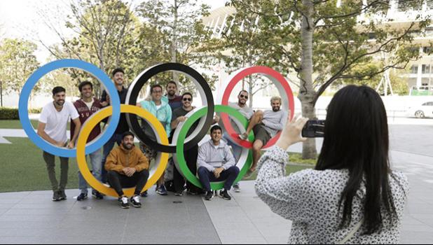 A group of students from Uruguay pose for a souvenir picture on the Olympic Rings set outside the Olympic Stadium in Tokyo, Saturday, March 21, 2020. The Olympic flame from Greece arrived in Japan Friday, even as the opening of the the Tokyo Games in four months is in doubt with more voices suggesting the games should to be postponed or canceled because of the worldwide virus pandemic. (AP Photo/Gregorio Borgia) A group of students from Uruguay pose for a souvenir picture on the Olympic Rings set outside the Olympic Stadium in Tokyo