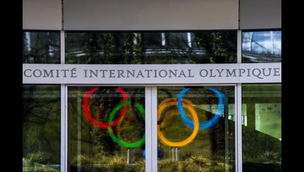 The Olympic Rings are displayed at the entrance of the IOC, International Olympic Committee headquarters during the coronavirus disease (COVID-19) outbreak in Lausanne, Switzerland, Tuesday, March 24, 2020. (Jean-Christophe Bott/Keystone via AP) The Olympic Rings are displayed at the entrance of the IOC