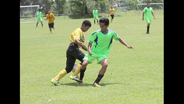 A Pago Youth players tries to dribble away from a Taputimu player