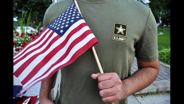 a Pakistani recruit, 22, who was recently discharged from the U.S. Army, holds an American flag as he poses for a picture. The man asked his name and location to be undisclosed for safety reasons. The AP interviewed three recruits from Brazil, Pakistan and Iran, all of whom said they were devastated by their unexpected discharges