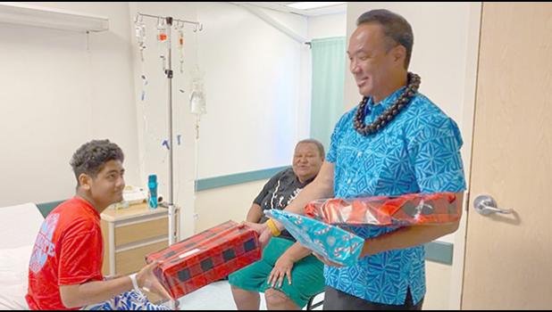A young man named Troy receives a gift from Paul Young on behalf of Rotary Club of Pago Pago