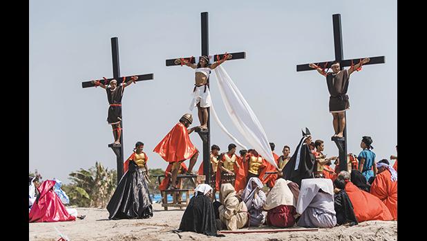 Ruben Enaje, center, dressed as Jesus, is seen nailed on cross for the 33rd year in a row during a reenactment of Jesus Christ's sufferings as part of Good Friday rituals in the village of San Pedro Cutud, Pampanga province, northern Philippines. Friday, April 19, 2019. Over a thousand Filipino Roman Catholic devotees and tourists flocked to a farming village north of Manila on Friday to witness the crucifixion of several devotees in a costumed reenactment of Jesus Christ's sufferings, a gory annual tradition church leaders frown upon. (AP Photo/Iya Forbes) Ruben Enaje, center, dressed as Jesus, is seen nailed on cross