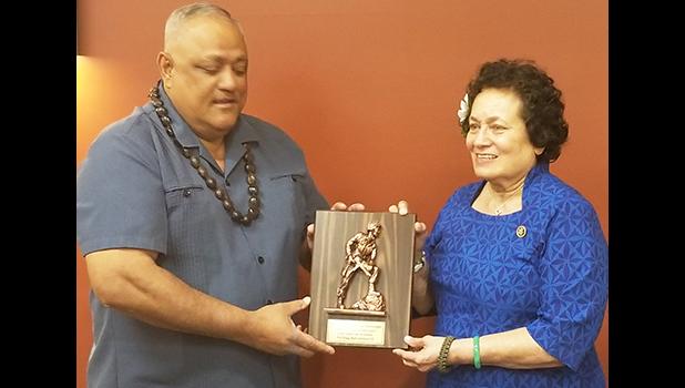 Robert “Koko” Yandall, retired Chief Warrant Officer 5, from Leone Village, presents Amata with a plaque from the Soldiers and Veteran Retirees at Fort Bragg. [courtesy photo]