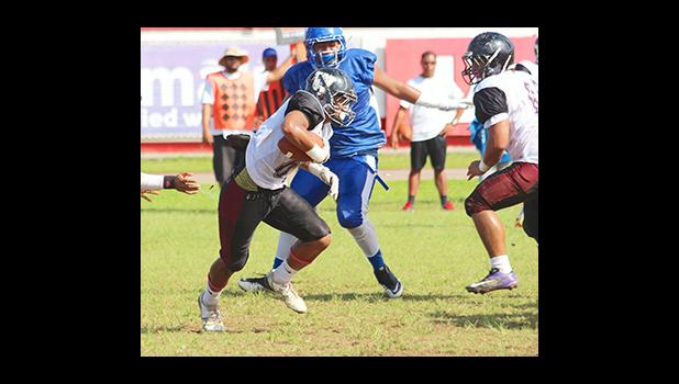 Andrew Toilolo trying to find an open gap between the trenches during the first half of their varsity play-off game against the Sharks last Saturday morning – Tafuna defeated Samoana 14 - 6. [photo: TG]