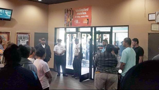 Police standing by the front door as movie goers file out of the Theatre