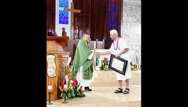 shows Tualauta Faipule Larry S. Sanitoa (right) shaking hands with Bishop Kolio Etuale Tumanuvao,
