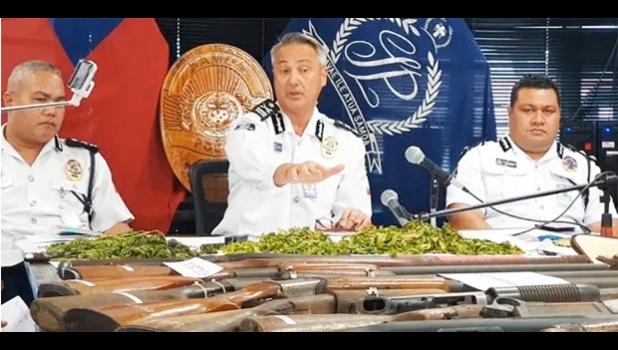 Samoa Police Commissioner along with two other officers in front of guns confiscated.