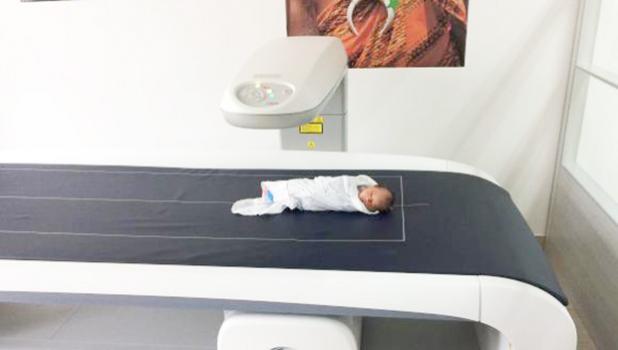 A Samoan infant rests in a special scanner that measures body composition. It is the first such scanner installed in a Pacific Island nation. [Image courtesy Stephen McGarvey vis Brown Univ. website]