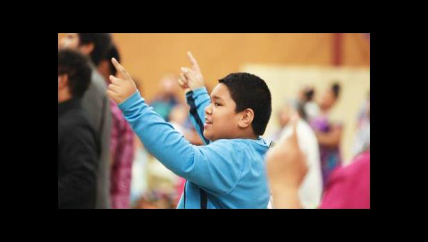 A young boy joins in singing praises to God at the Pacific Northwest Samoan Camp Meeting held at Sunset Lake Camp. Youth and adults alike participated in a training session on blending faith and culture